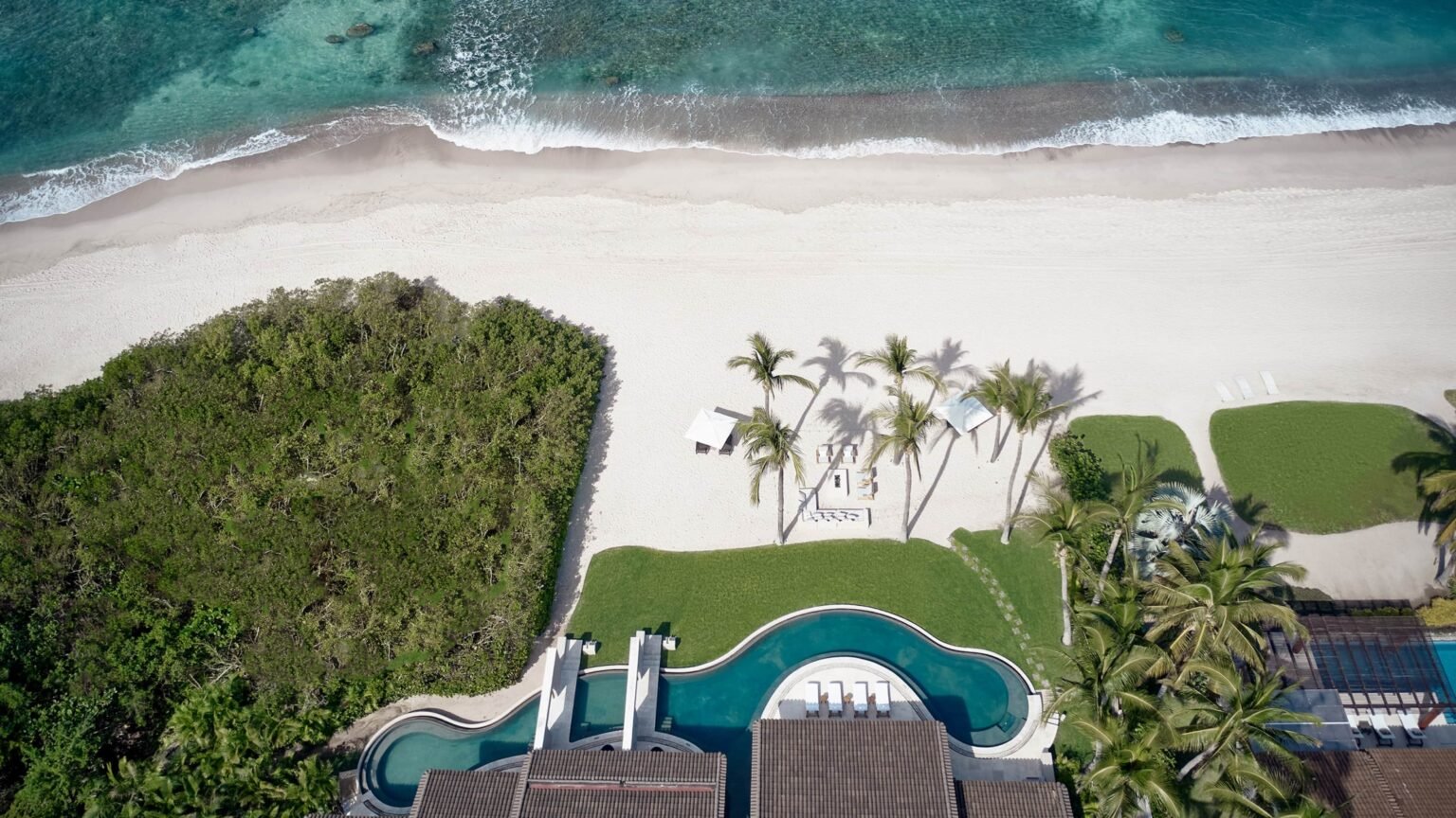 Aerial view of the beachfront ceremony lawn, palms and sand at Four Seasons Punta Mita on Mexico's Riviera Nayarit