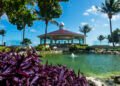 The Chapel of the Immaculate Conception at Moon Palace Cancun, a domed white chapel with a cupola and red tiled roof set beside a landscaped water feature and palm trees
