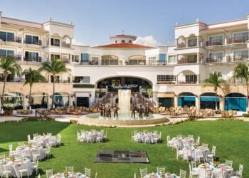 Central Garden at Hyatt Vivid Playa del Carmen set with round tables for a wedding reception in front of the resort fountain