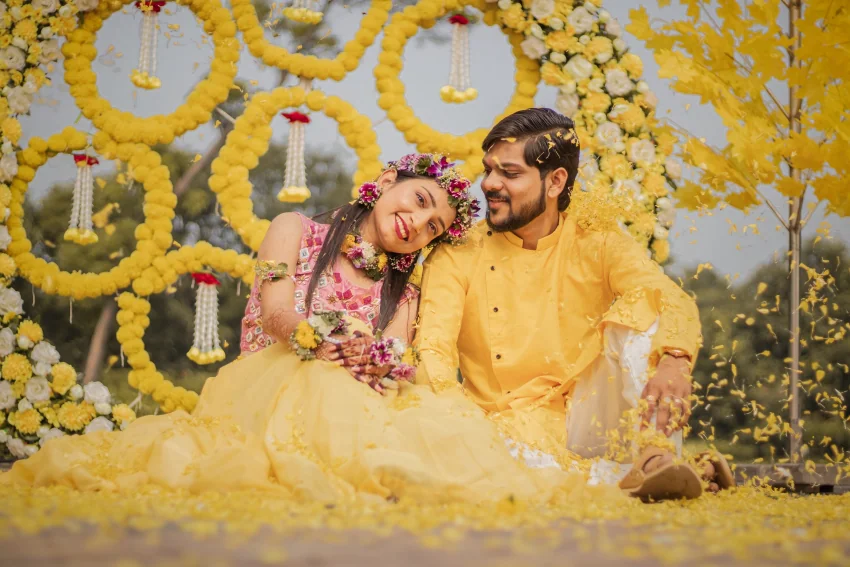 Haldi ceremony with turmeric paste being applied to the couple, part of a multi-day South Asian wedding celebration