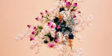 Cascading pink and blue floral wedding arrangement in a pastel garden setting